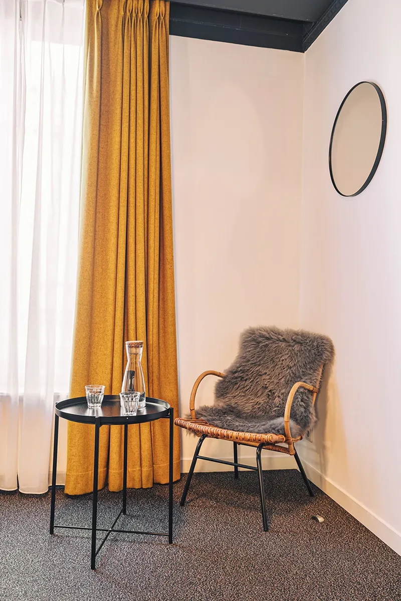 Chambre Confort Twin du Zoom Hotel à Bruxelles avec fauteuil, table basse et ambiance cosy